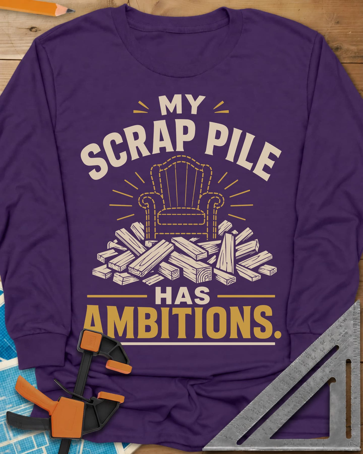 My Scrap Pile Has Ambitions long sleeve shirt in Purple, a dotted gold armchair outline rising from a pile of wood offcuts