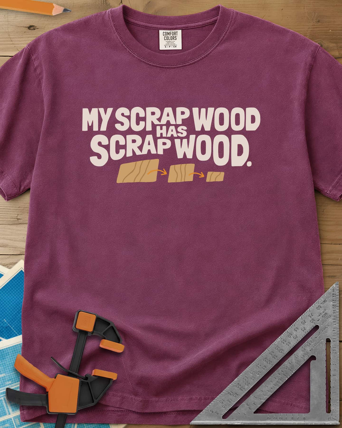 My Scrap Wood Has Scrap Wood heavyweight tee in Berry, three wood pieces getting smaller, linked by orange arrows
