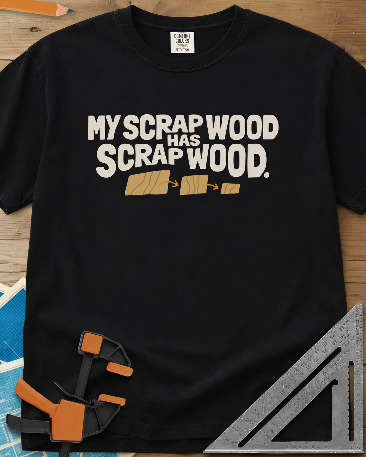 My Scrap Wood Has Scrap Wood heavyweight tee in Black, three wood pieces getting smaller, linked by orange arrows