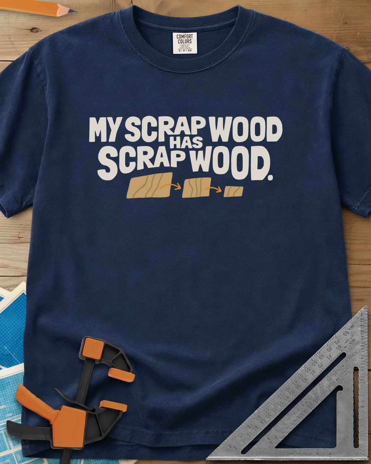 My Scrap Wood Has Scrap Wood heavyweight tee in Navy, three wood pieces getting smaller, linked by orange arrows