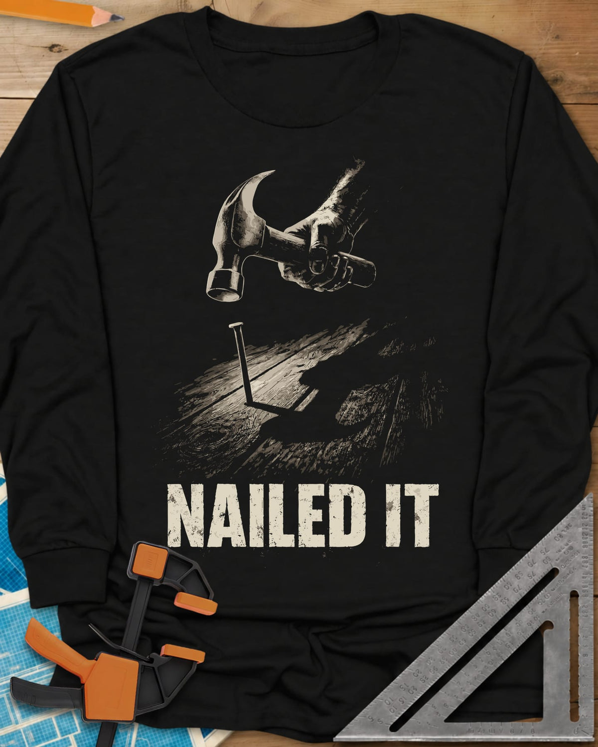Nailed It Hammer long sleeve shirt in Black, a hand raising a claw hammer over a nail in rough boards