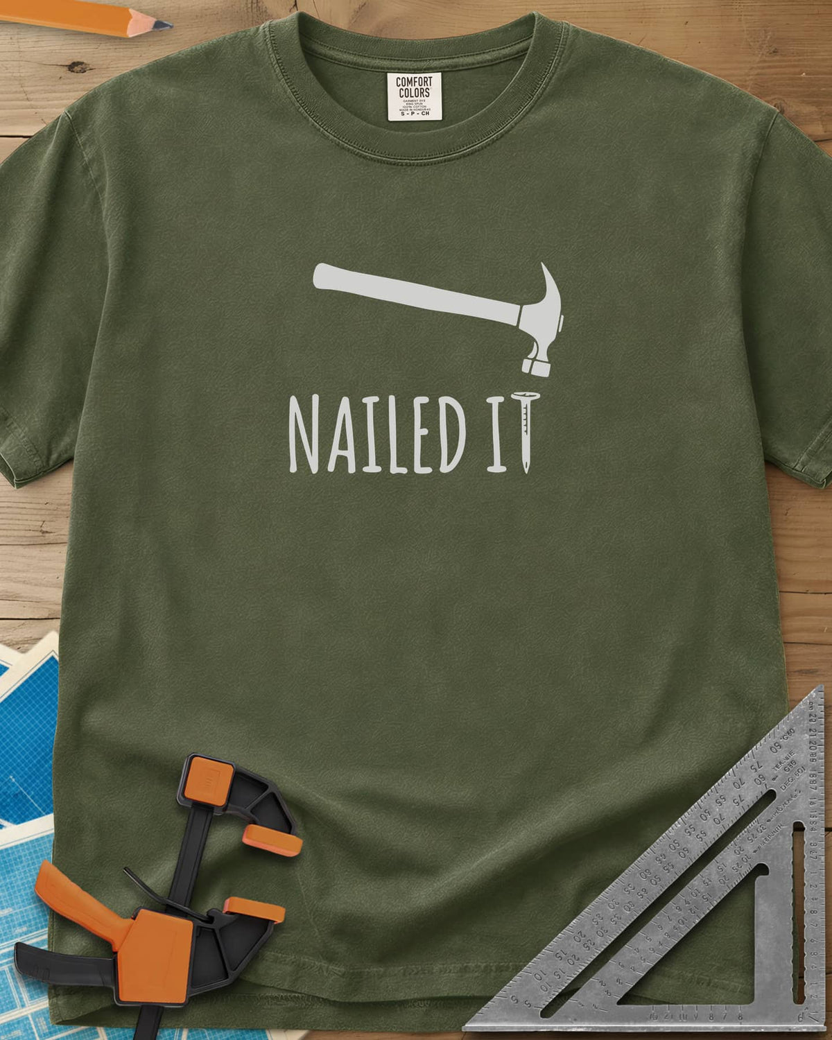 Nailed It heavyweight tee in Hemp, a hammer over a nail that forms the T in IT