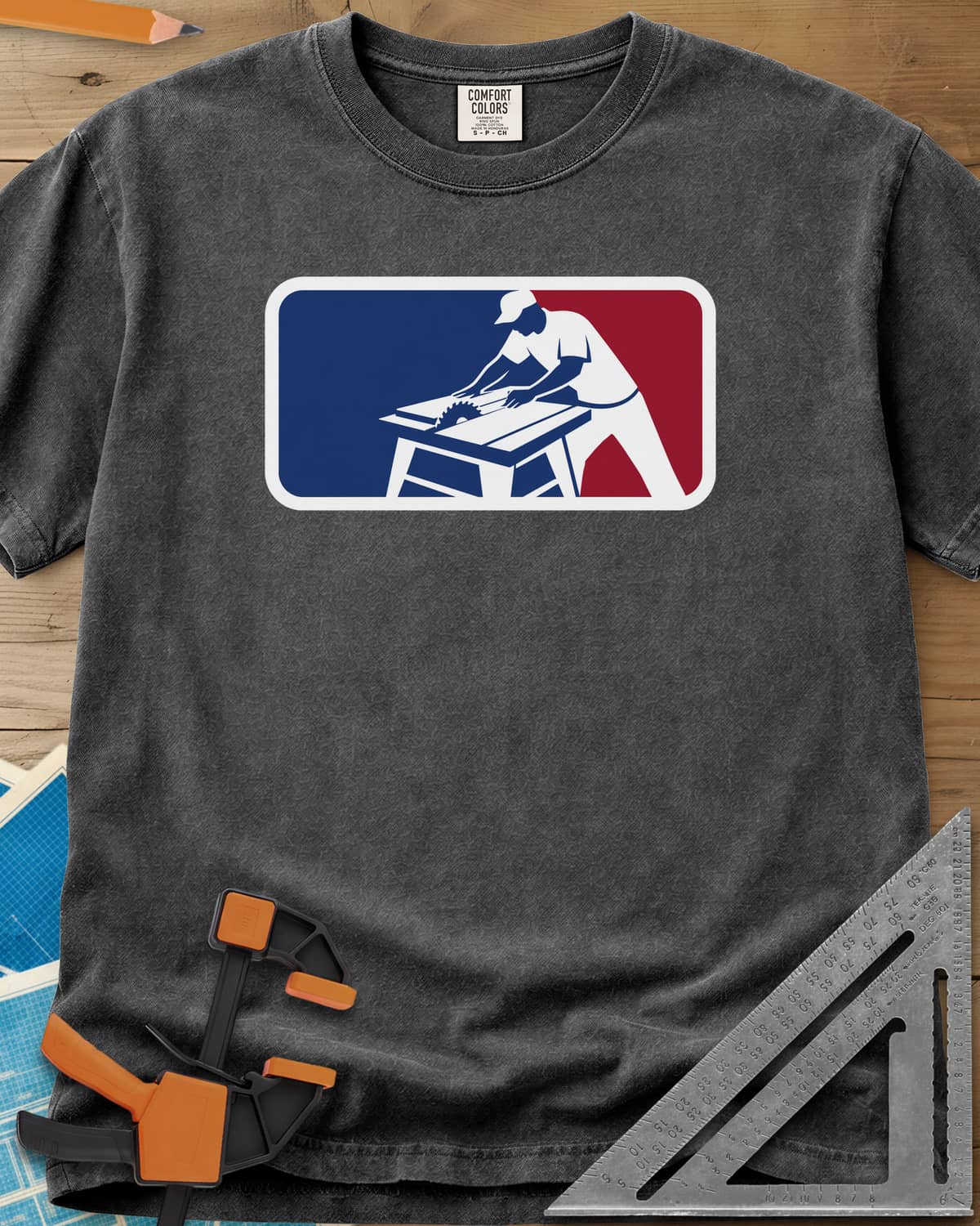 National Woodworking Association heavyweight tee in Pepper, a worker in a cap leaning over a table saw in a red and blue