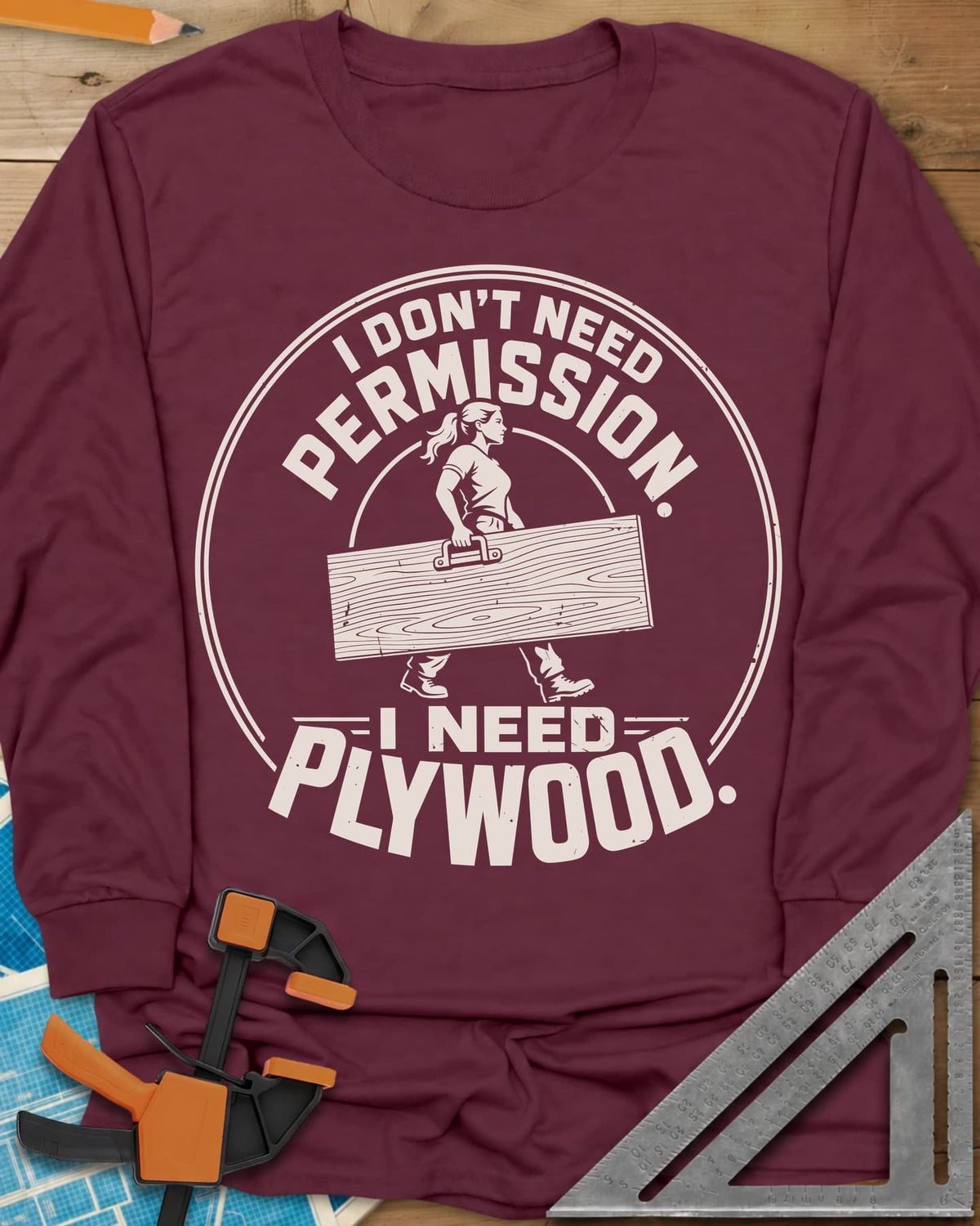 Need Plywood long sleeve shirt in Maroon, a woman with a ponytail carrying a plywood sheet in a round badge