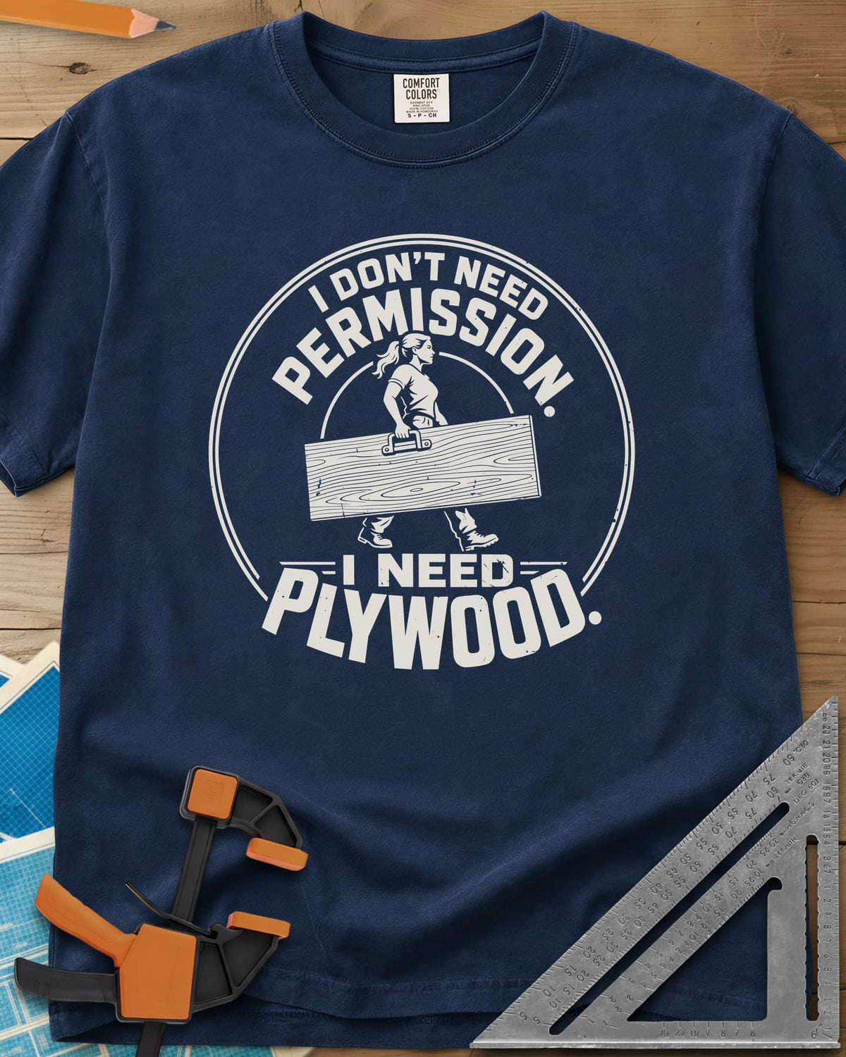 Need Plywood heavyweight tee in Navy, a woman with a ponytail carrying a plywood sheet in a round badge