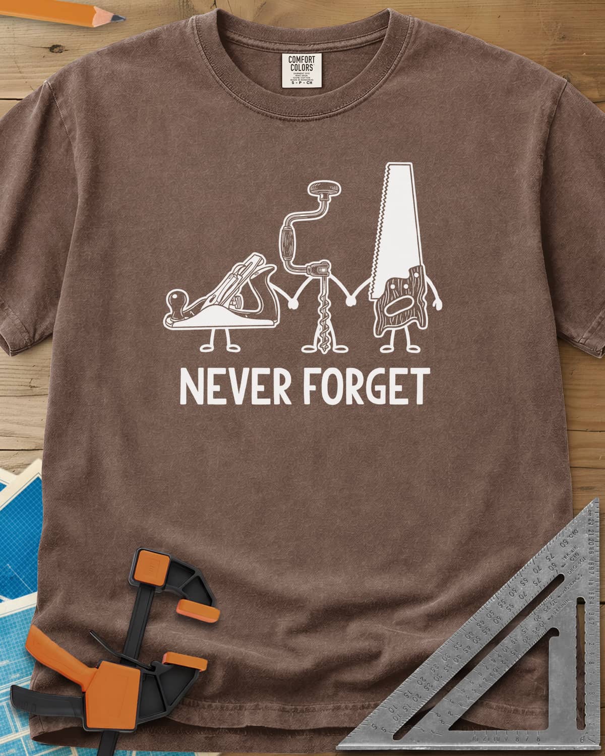Never Forget heavyweight tee in Espresso, three cartoon hand tools holding hands: a plane, a brace and a saw