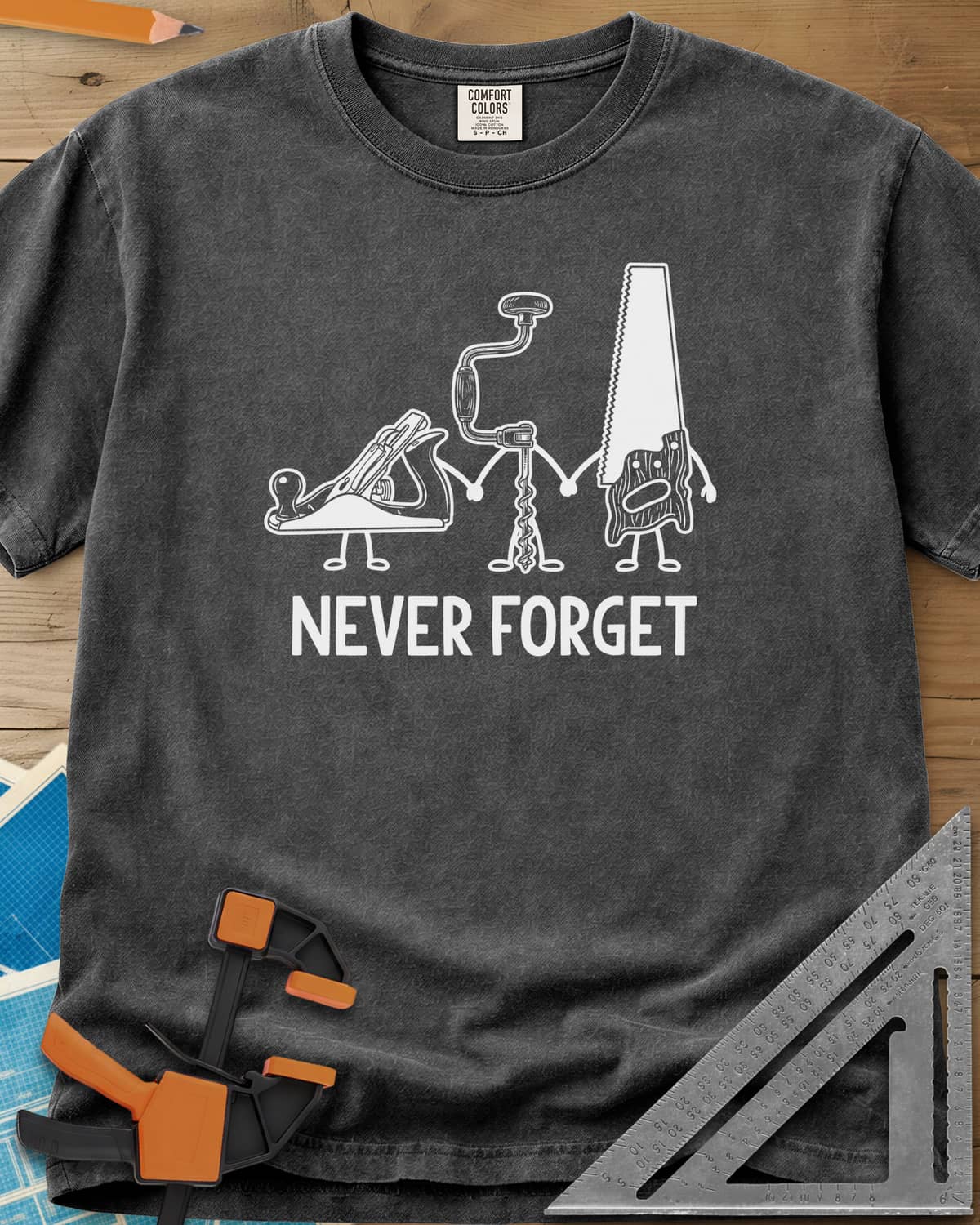 Never Forget heavyweight tee in Pepper, three cartoon hand tools holding hands: a plane, a brace and a saw