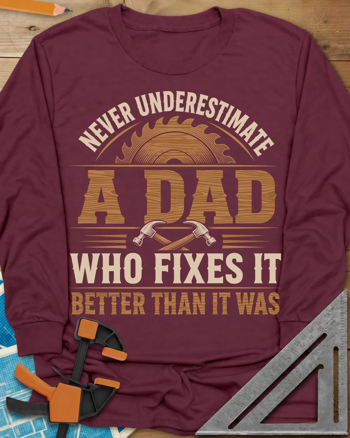 Never Underestimate A Dad Who Fixes It long sleeve shirt in Maroon, saw blade and two crossed hammers around wood-grain