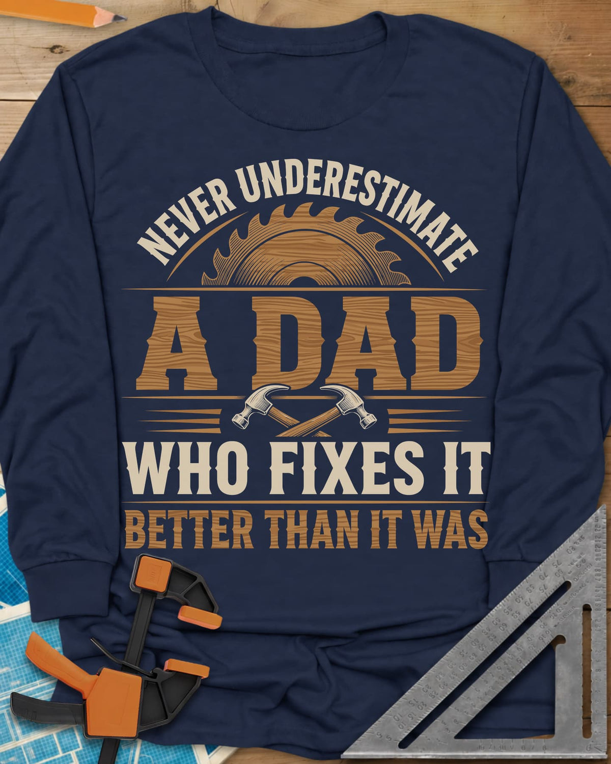 Never Underestimate A Dad Who Fixes It long sleeve shirt in Navy, saw blade and two crossed hammers around wood-grain