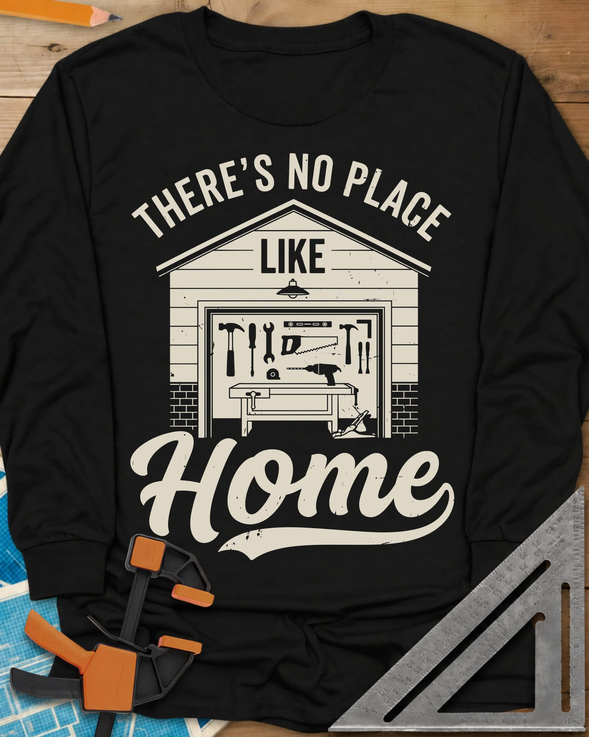 No Place Like Home long sleeve shirt in Black, a garage with its door up on a tool wall, above script Home