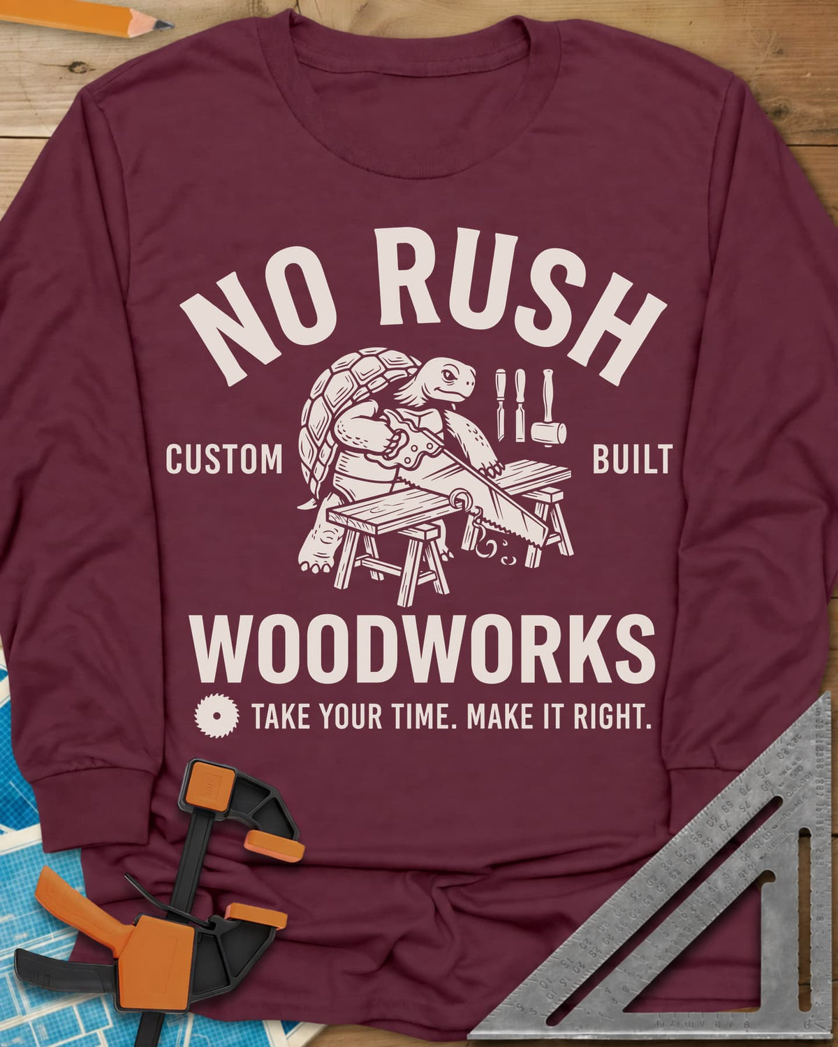 No Rush Woodworks long sleeve shirt in Maroon, a tortoise sawing a board on sawhorses inside a woodshop badge