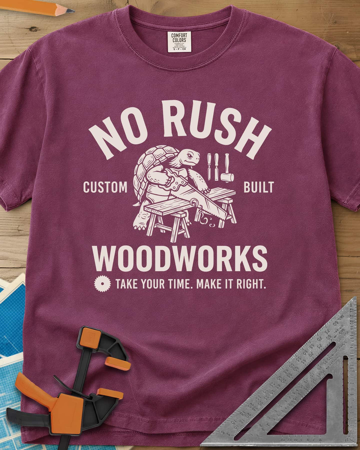 No Rush Woodworks heavyweight tee in Berry, a tortoise sawing a board on sawhorses inside a woodshop badge