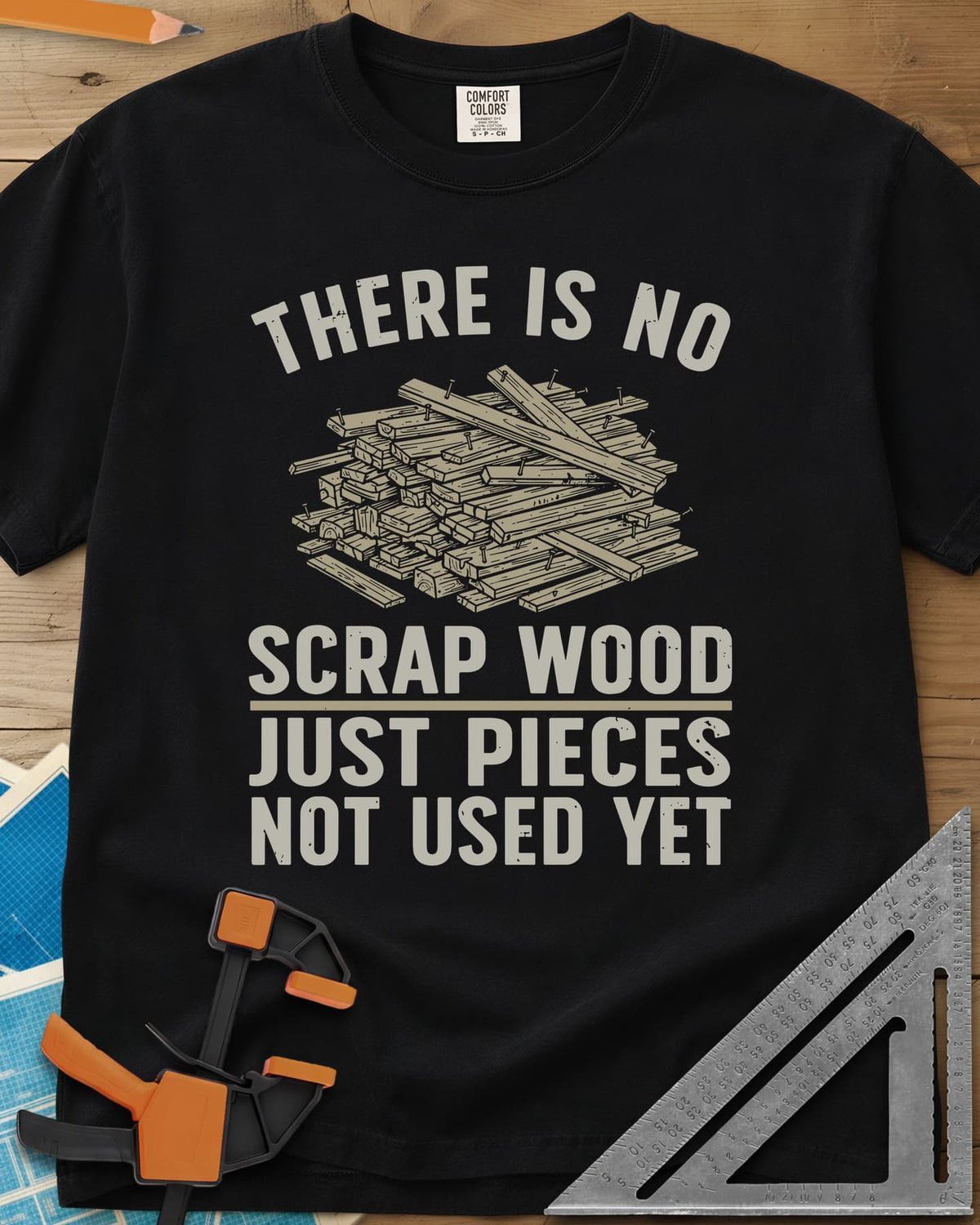 No Scrap Wood heavyweight tee in Black, a tall pile of offcut boards with a few nails sticking out