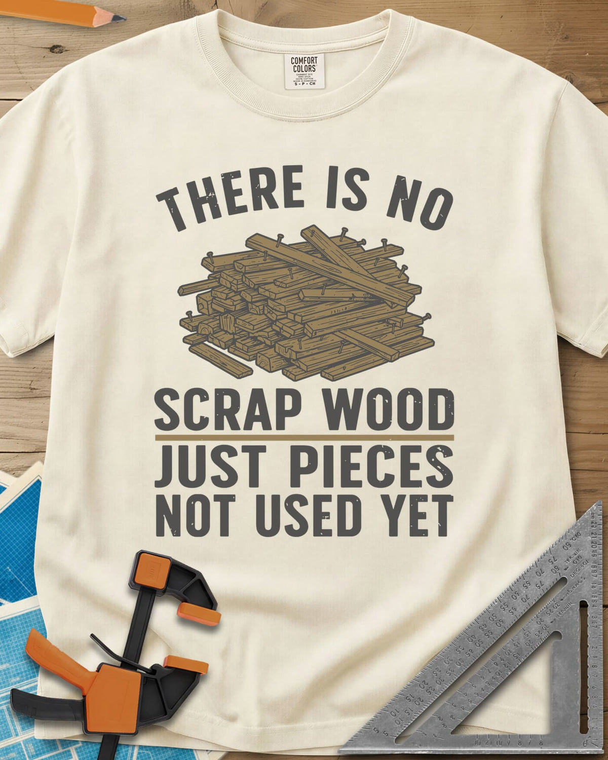 No Scrap Wood heavyweight tee in Ivory, a tall pile of offcut boards with a few nails sticking out