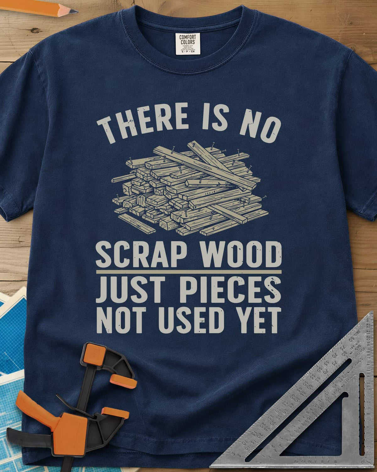 No Scrap Wood heavyweight tee in Navy, a tall pile of offcut boards with a few nails sticking out