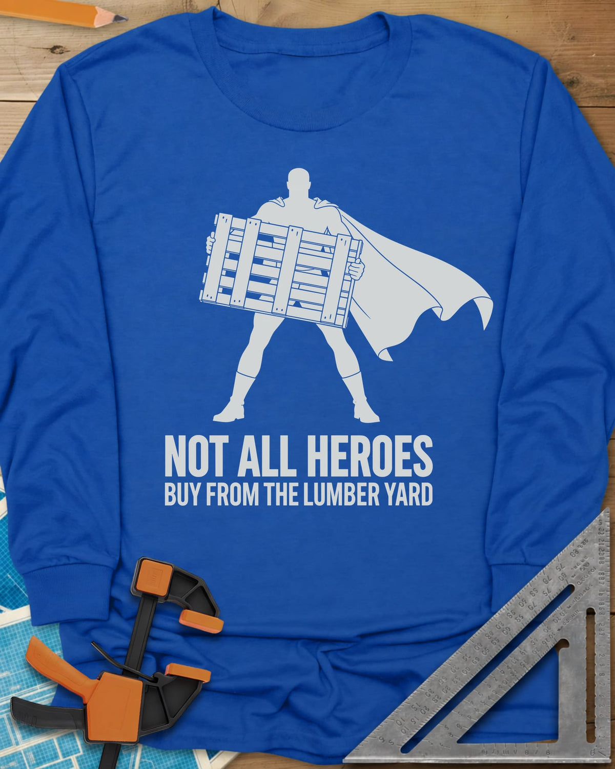 Not All Heroes long sleeve shirt in Royal, a caped hero silhouette holding a wooden shipping pallet