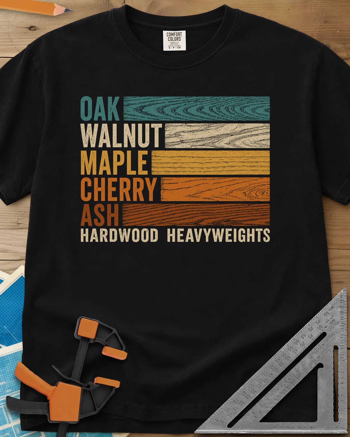 Oak Walnut Maple Cherry Ash heavyweight tee in Black, five wood names beside strips of their own grain in retro colors