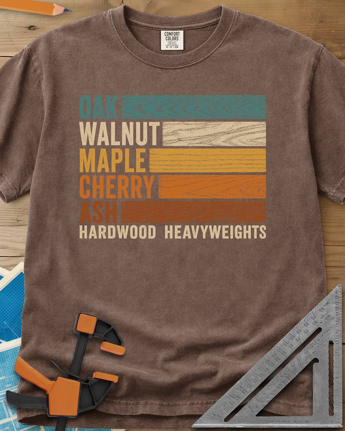 Oak Walnut Maple Cherry Ash heavyweight tee in Espresso, five wood names beside strips of their own grain in retro colors