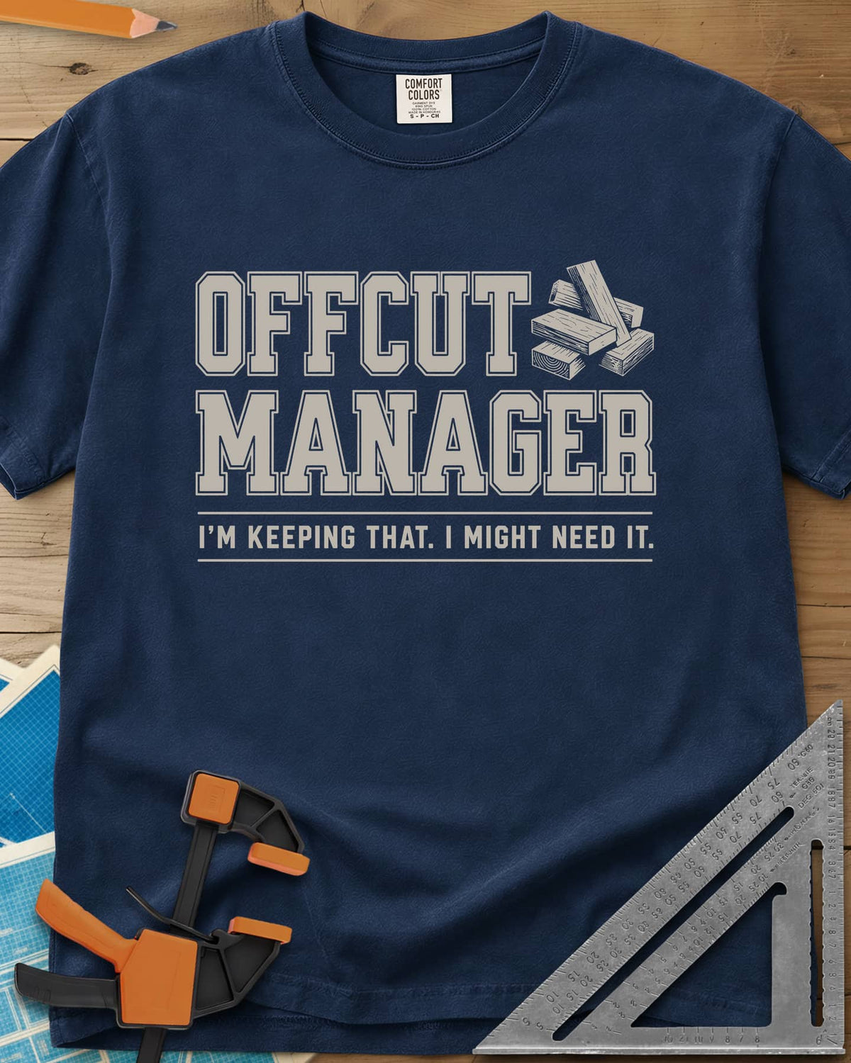 Offcut Manager heavyweight tee in Navy, varsity block lettering beside a little stack of wood offcuts