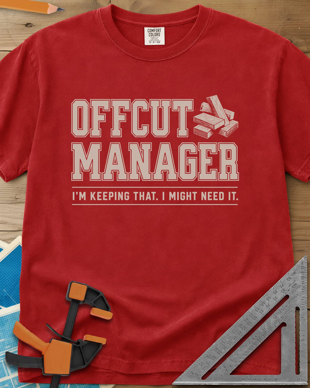 Offcut Manager heavyweight tee in Red, varsity block lettering beside a little stack of wood offcuts
