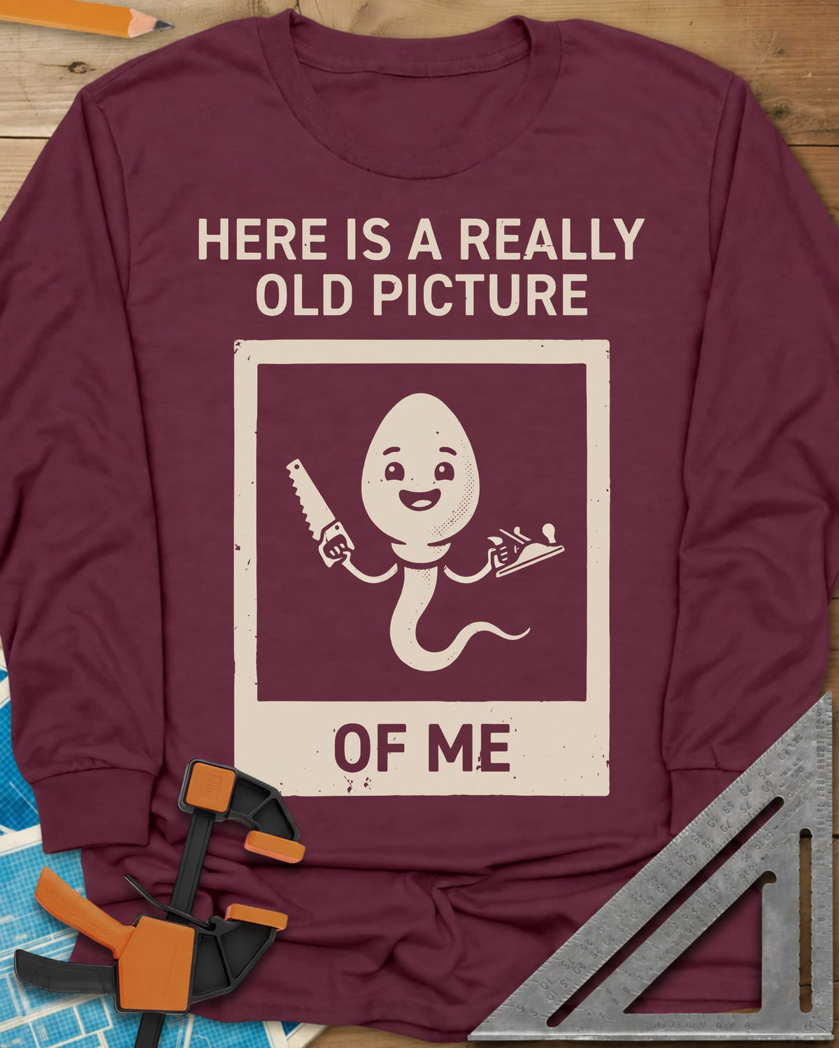 Old Picture long sleeve shirt in Maroon, a smiling cartoon figure with a long tail holding a saw and a plane