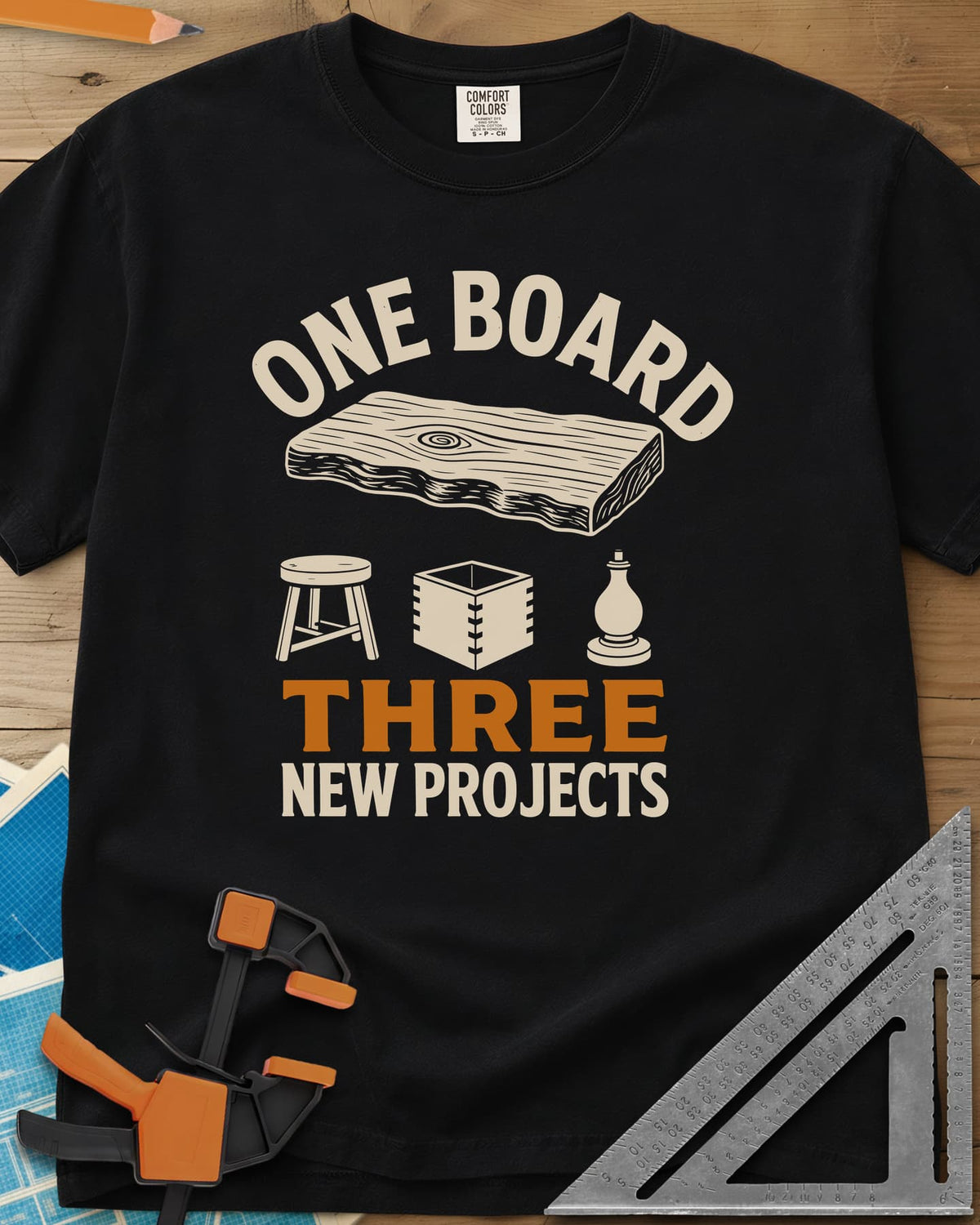 One Board heavyweight tee in Black, a live-edge board over a stool, a box and a turned chess piece