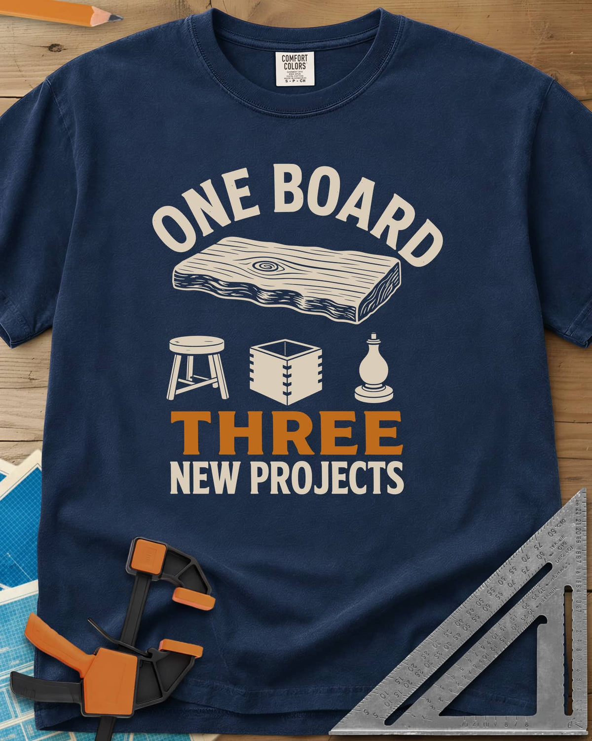 One Board heavyweight tee in Navy, a live-edge board over a stool, a box and a turned chess piece
