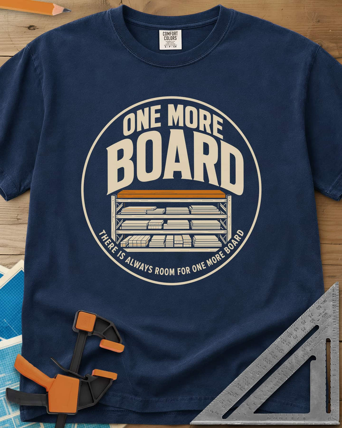 One More Board heavyweight tee in Navy, a round badge with a rack of stacked lumber
