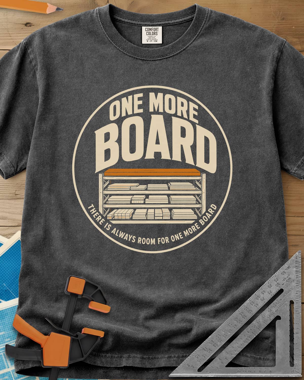 One More Board heavyweight tee in Pepper, a round badge with a rack of stacked lumber