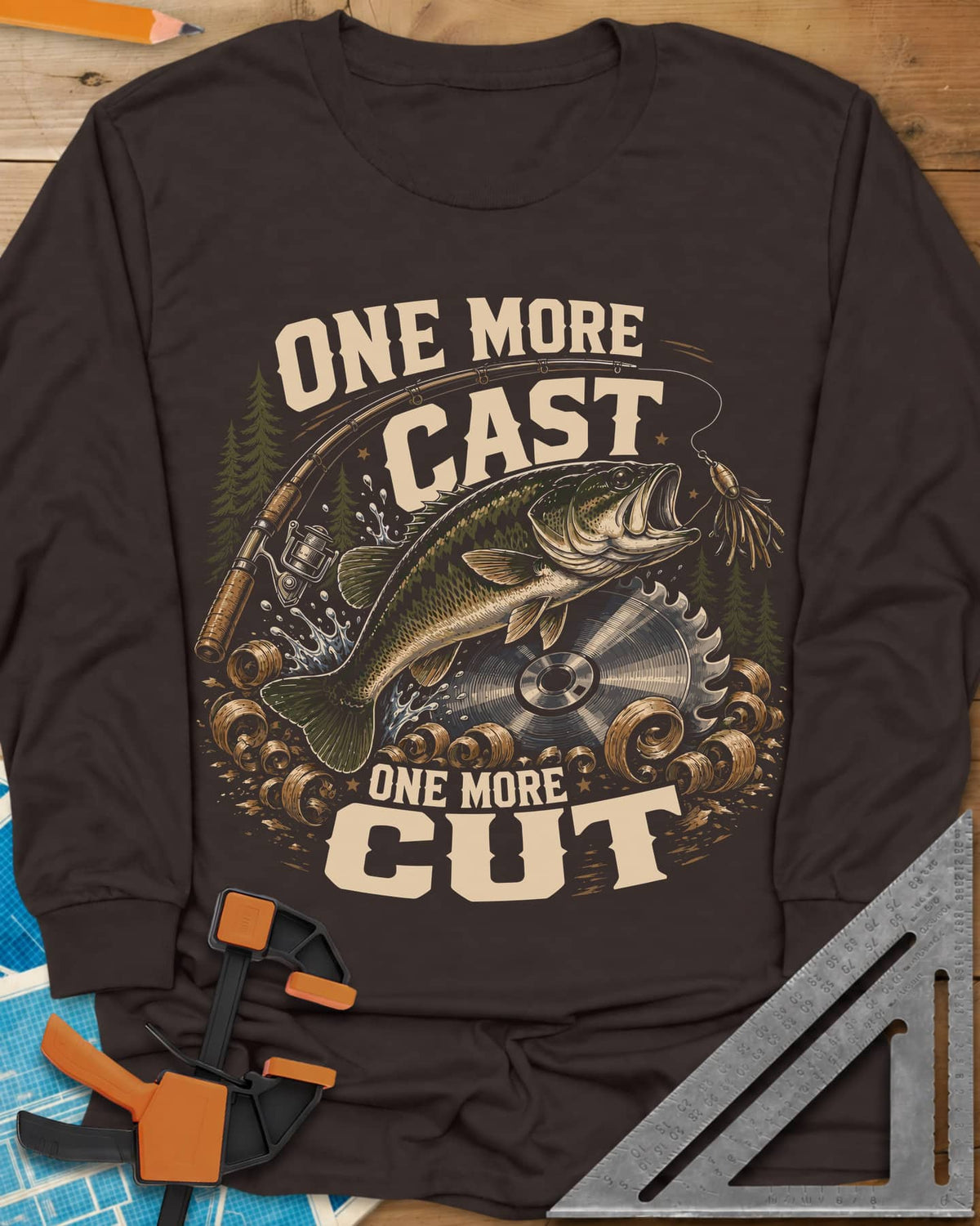 One More Cast One More Cut long sleeve shirt in Dark Chocolate, a leaping bass, saw blade, fishing rod and wood curls