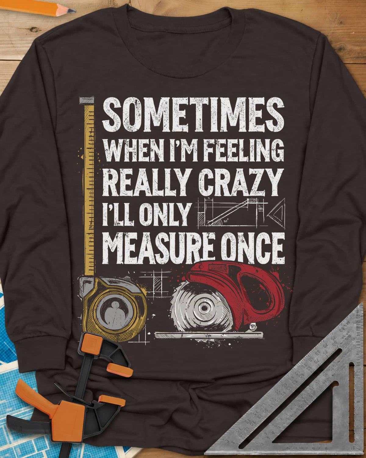 Only Measure Once long sleeve shirt in Dark Chocolate, block letters with a yellow tape measure and a red circular saw