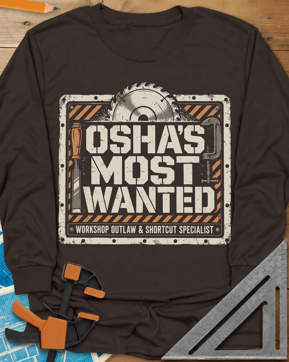 OSHA'S Most Wanted long sleeve shirt in Dark Chocolate, a saw blade, chisel and C-clamp around a hazard-striped plate