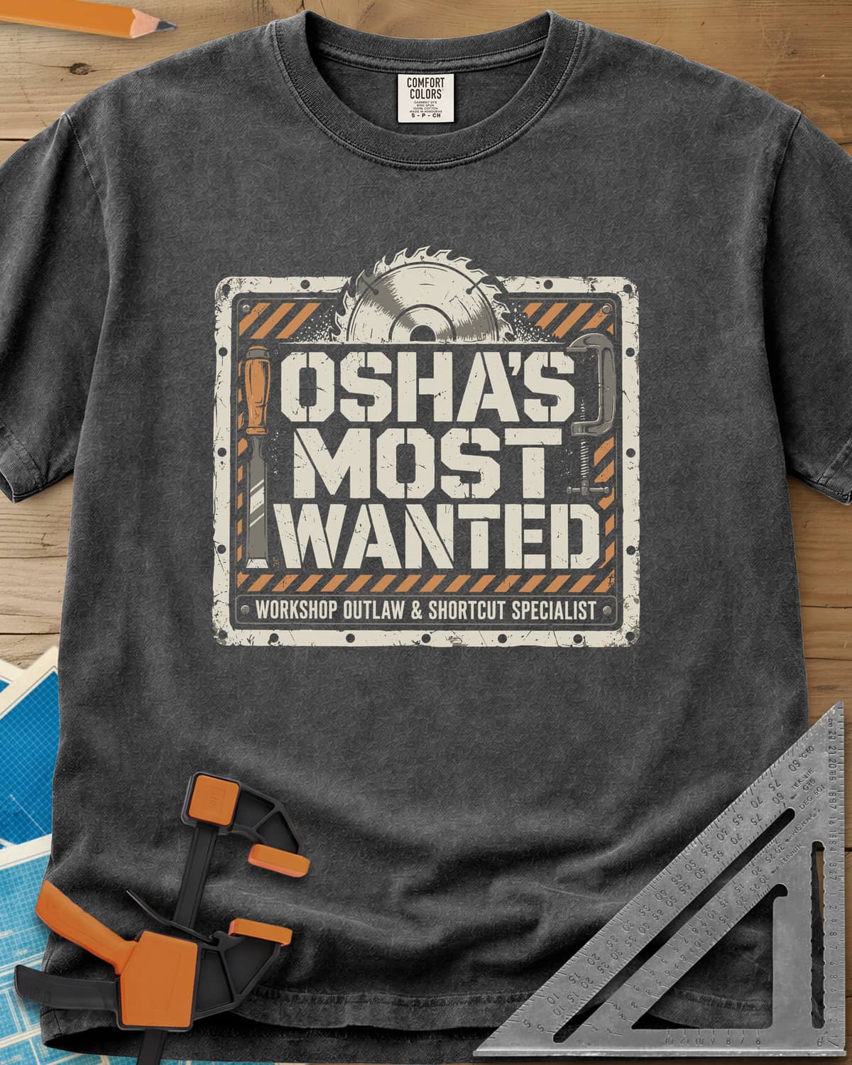 OSHA'S Most Wanted heavyweight tee in Pepper, a saw blade, chisel and C-clamp around a hazard-striped plate