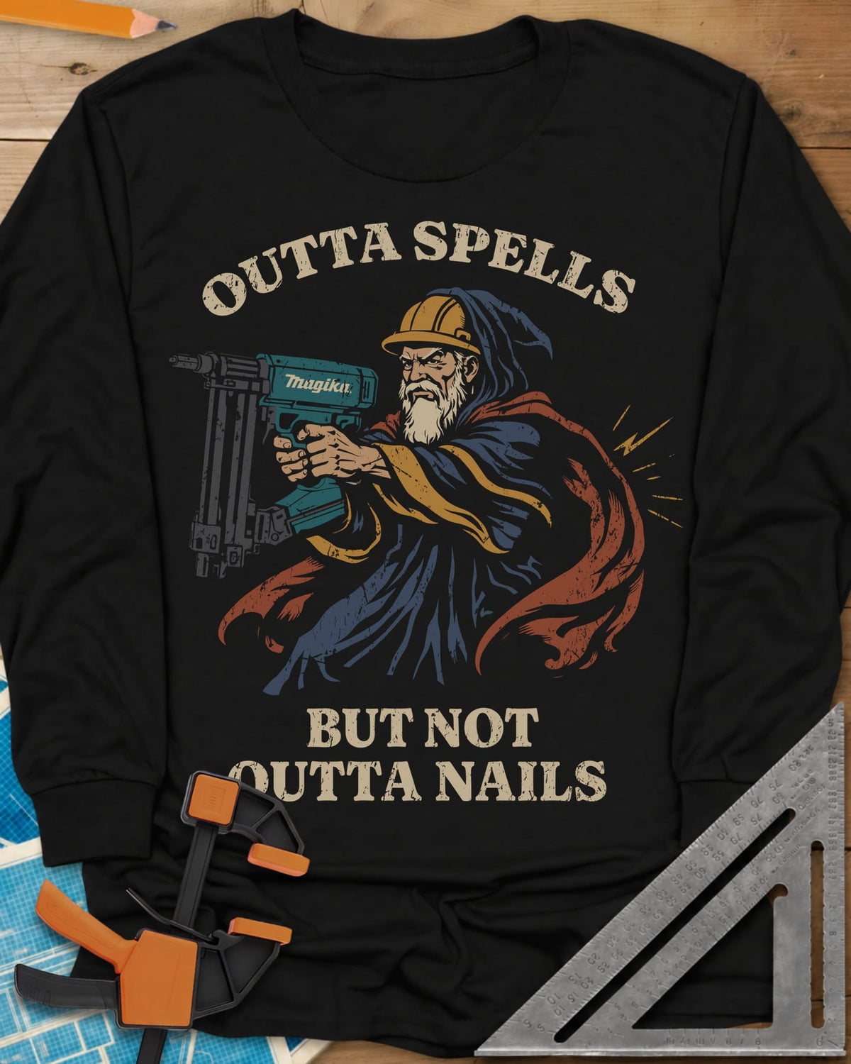 Outta Spells But Not Outta Nails long sleeve shirt in Black, a bearded wizard in a hard hat aiming a teal nail gun