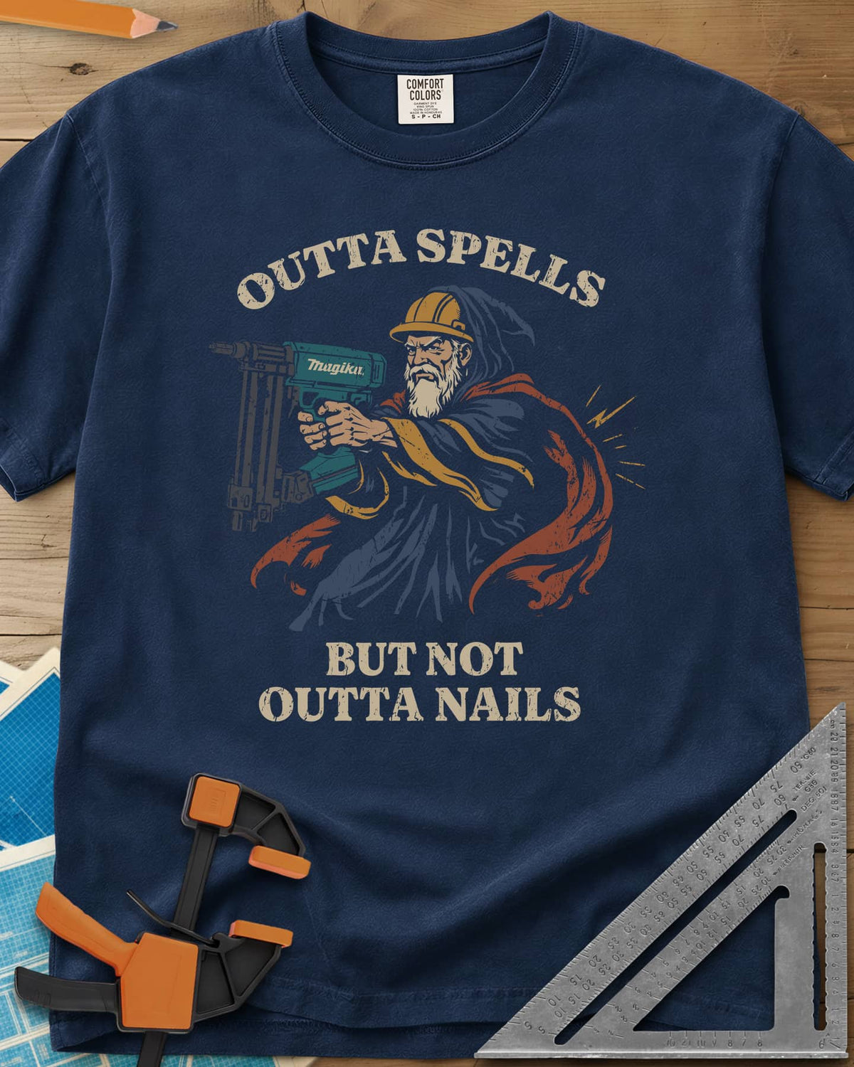 Outta Spells But Not Outta Nails heavyweight tee in Navy, a bearded wizard in a hard hat aiming a teal nail gun