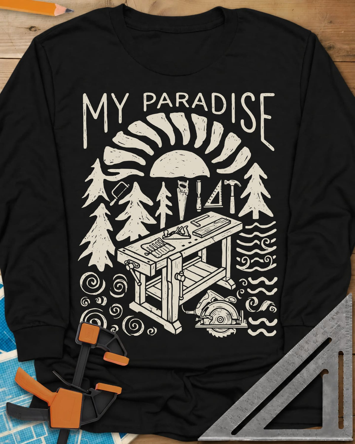 Paradise Workshop long sleeve shirt in Black, linocut sun, pines, hand tools and a workbench with a plane