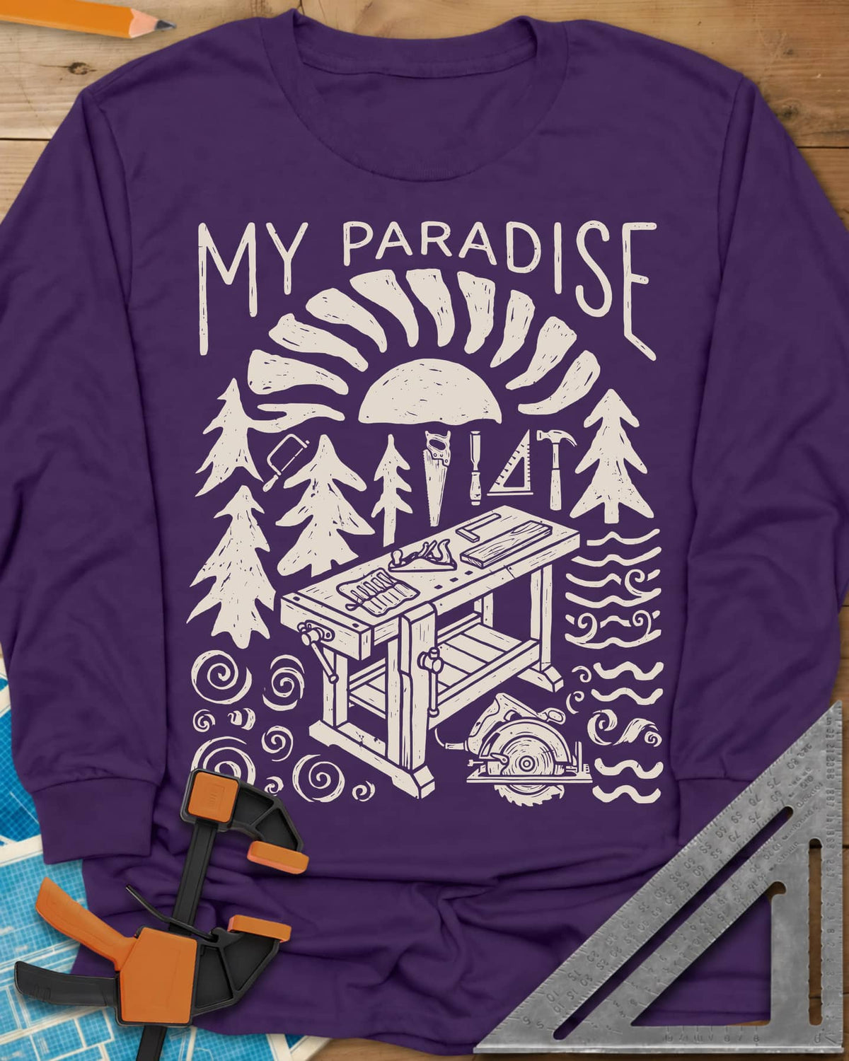 Paradise Workshop long sleeve shirt in Purple, linocut sun, pines, hand tools and a workbench with a plane