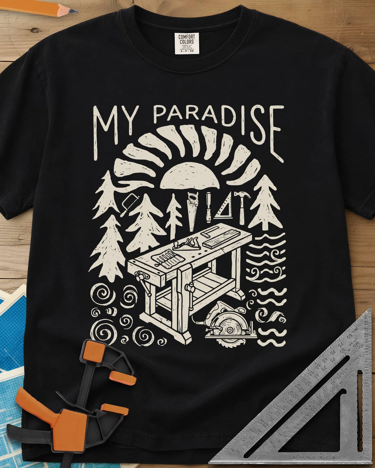 Paradise Workshop heavyweight tee in Black, linocut sun, pines, hand tools and a workbench with a plane