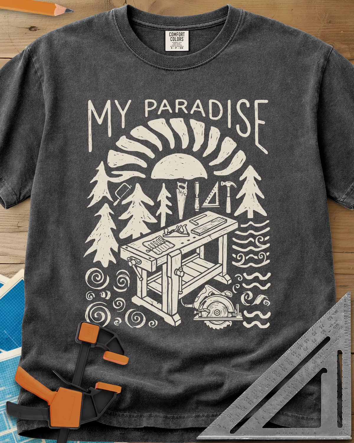 Paradise Workshop heavyweight tee in Pepper, linocut sun, pines, hand tools and a workbench with a plane