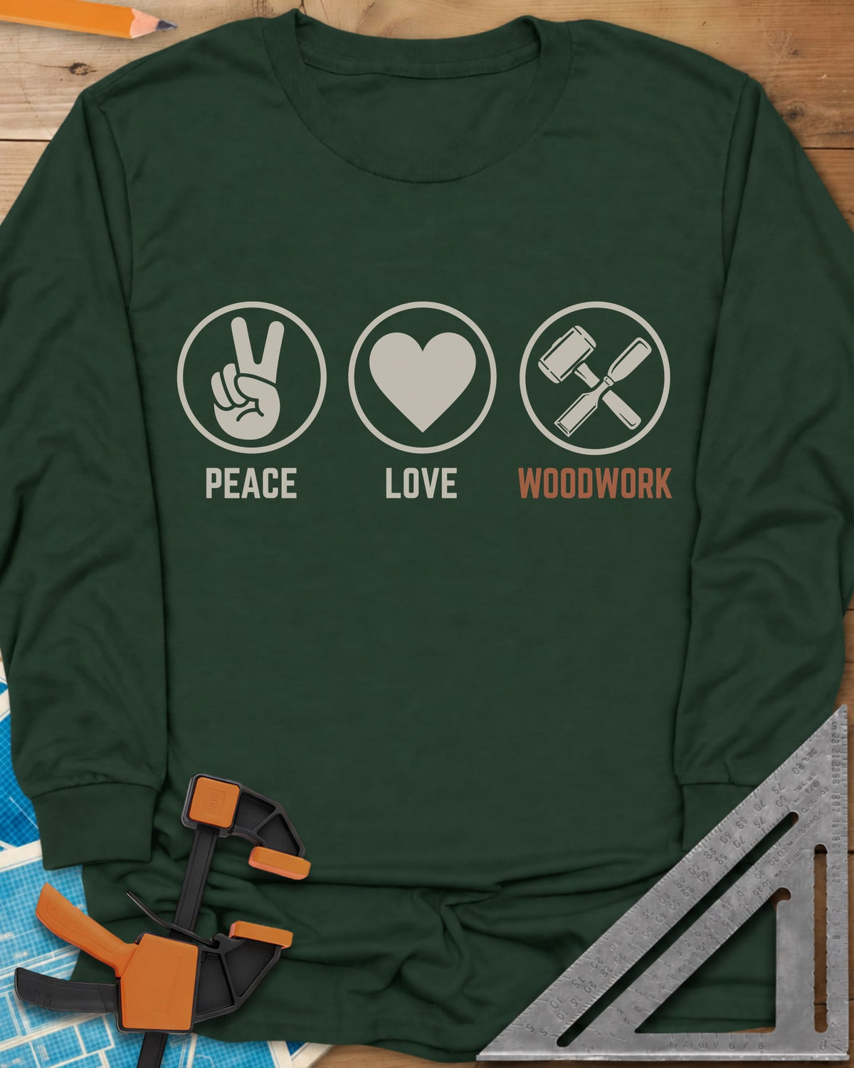 Peace Love Woodwork long sleeve shirt in Forest Green, three circled icons: a peace sign, a heart, a mallet and chisel