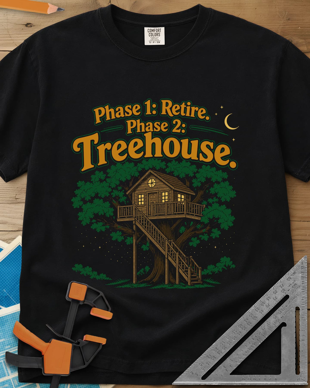 Phase 1 Retire Phase 2 Treehouse heavyweight tee in Black, a lit treehouse with a deck and long staircase under a night sky