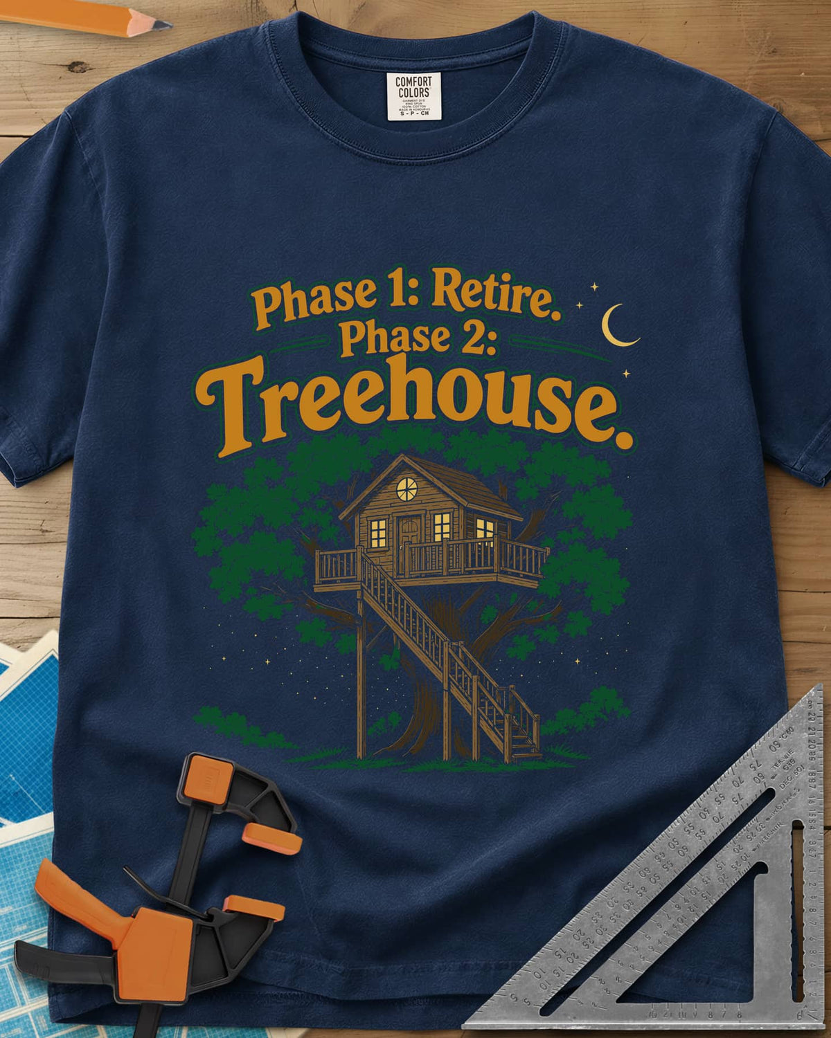 Phase 1 Retire Phase 2 Treehouse heavyweight tee in Navy, a lit treehouse with a deck and long staircase under a night sky