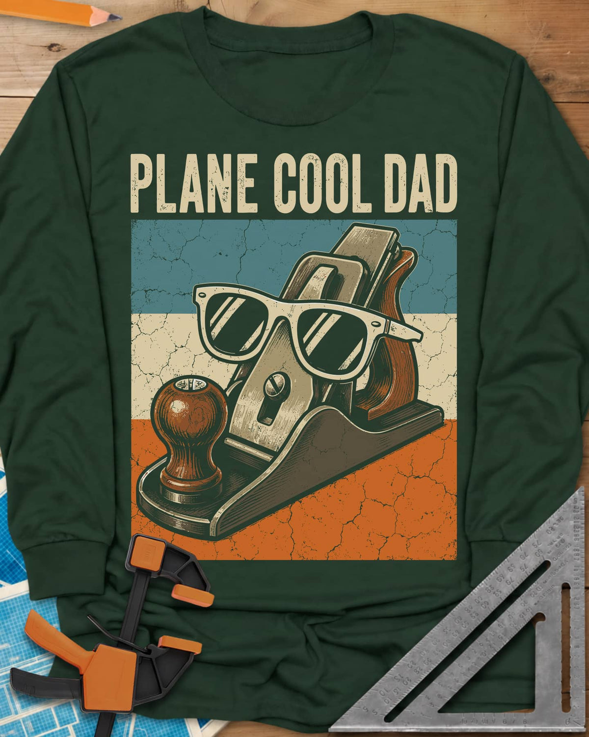Plane Cool Dad long sleeve shirt in Forest Green, a hand plane in white sunglasses on a retro striped panel