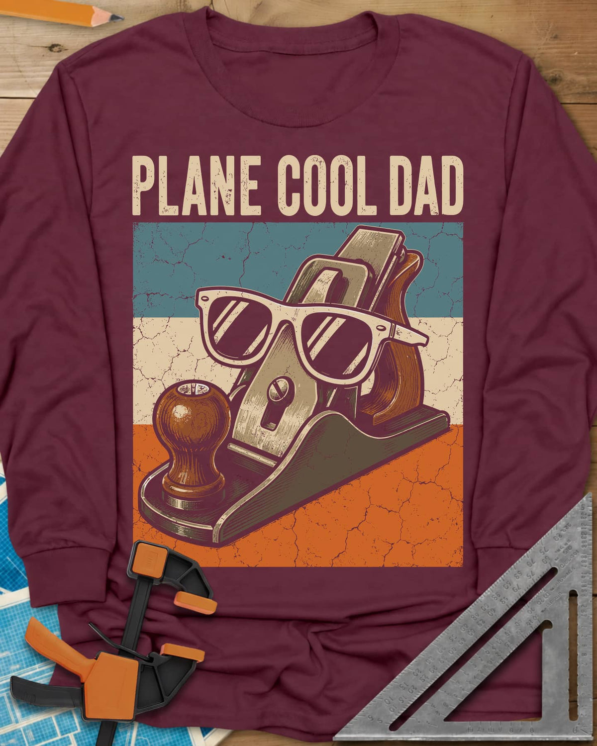 Plane Cool Dad long sleeve shirt in Maroon, a hand plane in white sunglasses on a retro striped panel