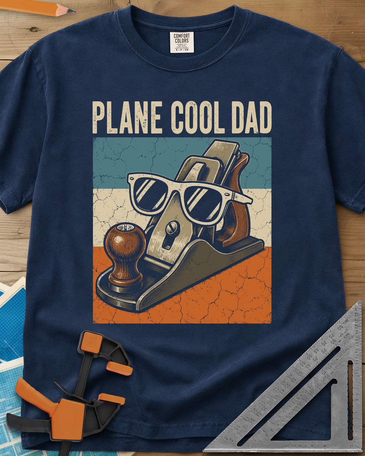 Plane Cool Dad heavyweight tee in Navy, a hand plane in white sunglasses on a retro striped panel