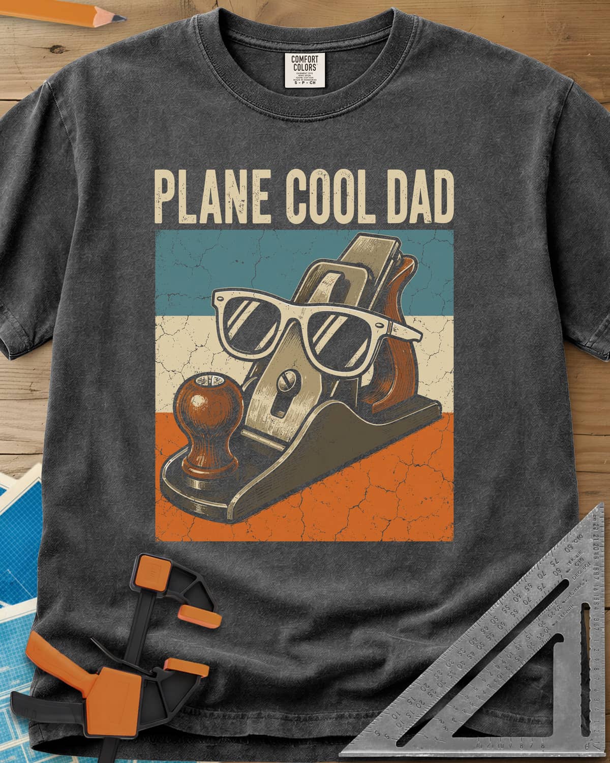 Plane Cool Dad heavyweight tee in Pepper, a hand plane in white sunglasses on a retro striped panel