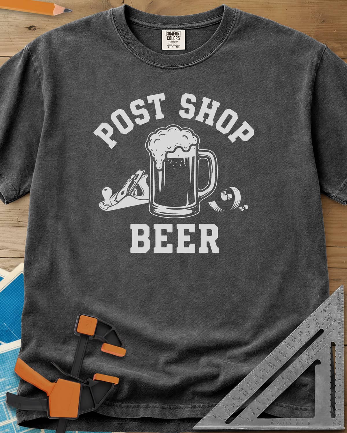 Post Shop Beer Woodworking heavyweight tee in Pepper, a frothy beer mug flanked by a hand plane and a wood shaving