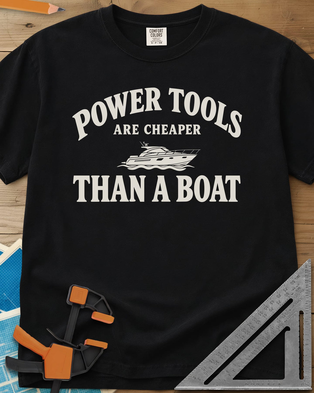 Power Tools Are Cheaper Than A Boat heavyweight tee in Black, a line-drawn motor yacht on waves between the words