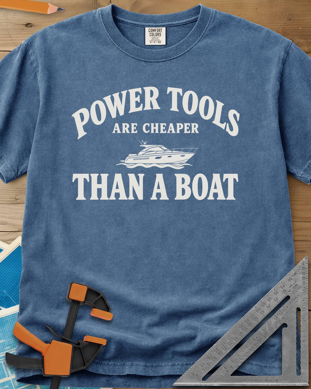 Power Tools Are Cheaper Than A Boat heavyweight tee in Blue Jean, a line-drawn motor yacht on waves between the words