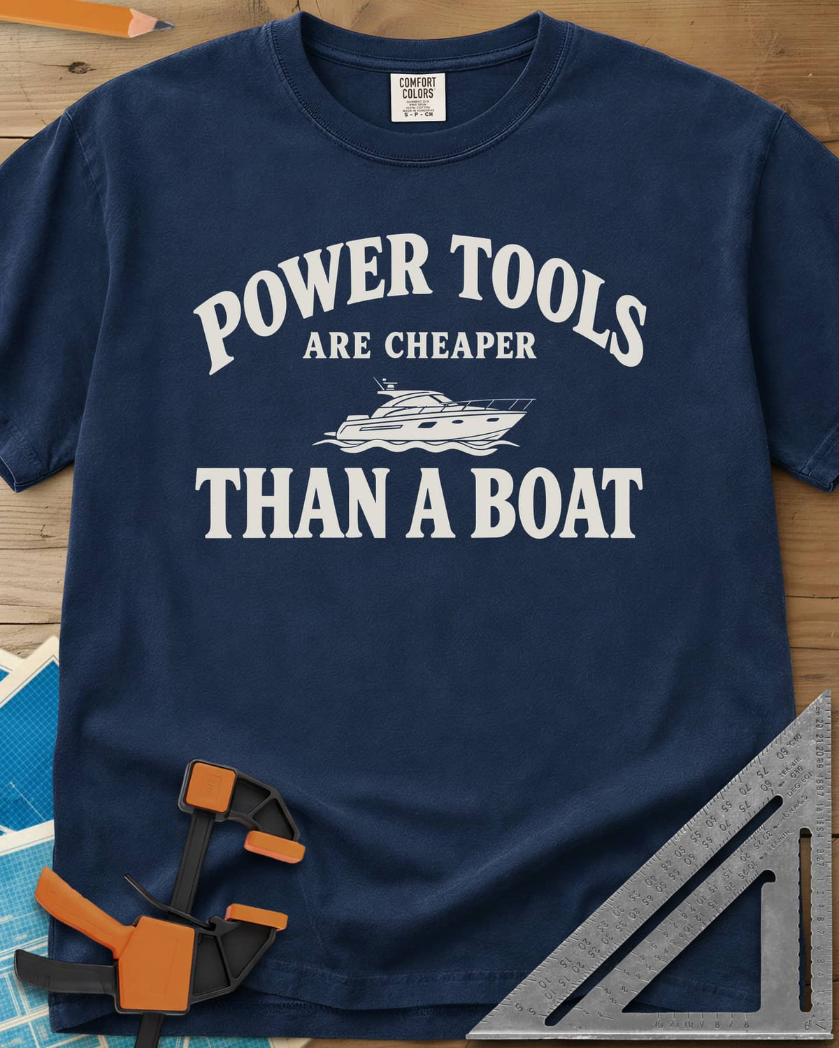 Power Tools Are Cheaper Than A Boat heavyweight tee in Navy, a line-drawn motor yacht on waves between the words